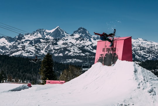 man doing snowboard tricks on ramp in Mammoth Mountain United States