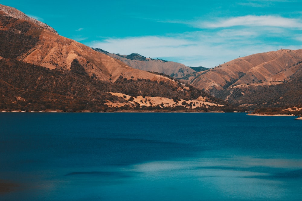 body of water surrounded by brown mountains