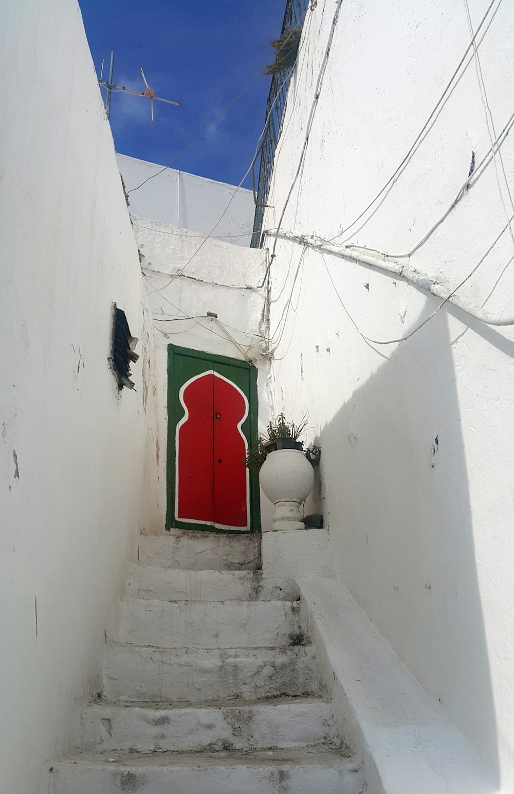 red-and-green door near white wall