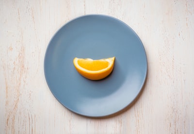 a blue plate with a half of an orange on it
