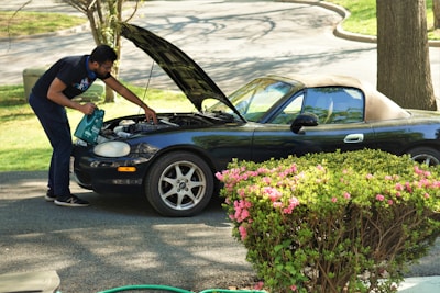 A car being inspected by a buyer in a driveway.