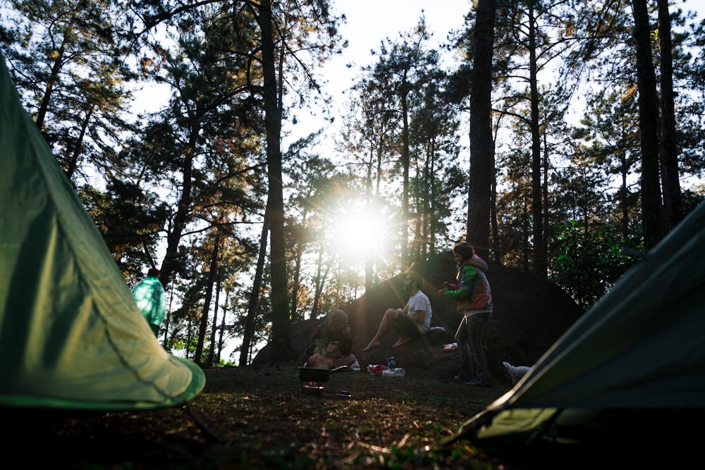 people sitting beside green dome tents during daytime