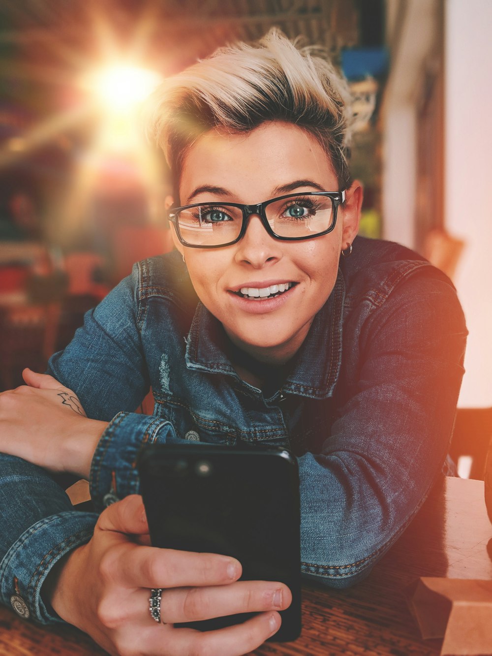 Frau mit Smartphone auf Holztisch