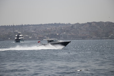 A sleek speedboat cutting through the sparkling waters of the Hudson River with the Manhattan skyline in the background.