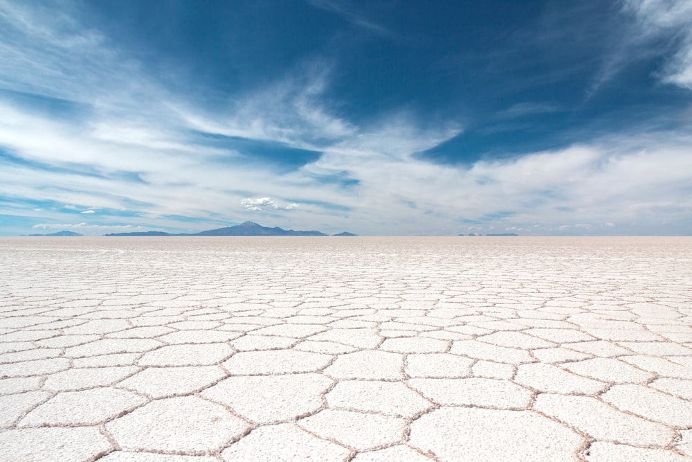 dry soil under white clouds and blue sky at daytime