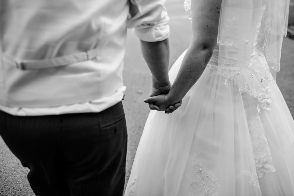grayscale photo of wedded couple holding hands