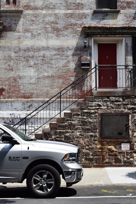 silver Dodge Ram 1500 near brown brick wall