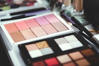 Close-up of colorful makeup palettes arranged on modern shelves.