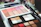 Close-up of colorful makeup palettes with brushes on a vanity table