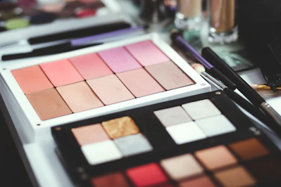 Close-up of a vibrant makeup palette with rich pink and brown tones on a soft off-white background