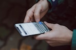 selective focus photography of person using smartphone