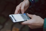 selective focus photography of person using smartphone