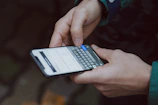 selective focus photography of person using smartphone
