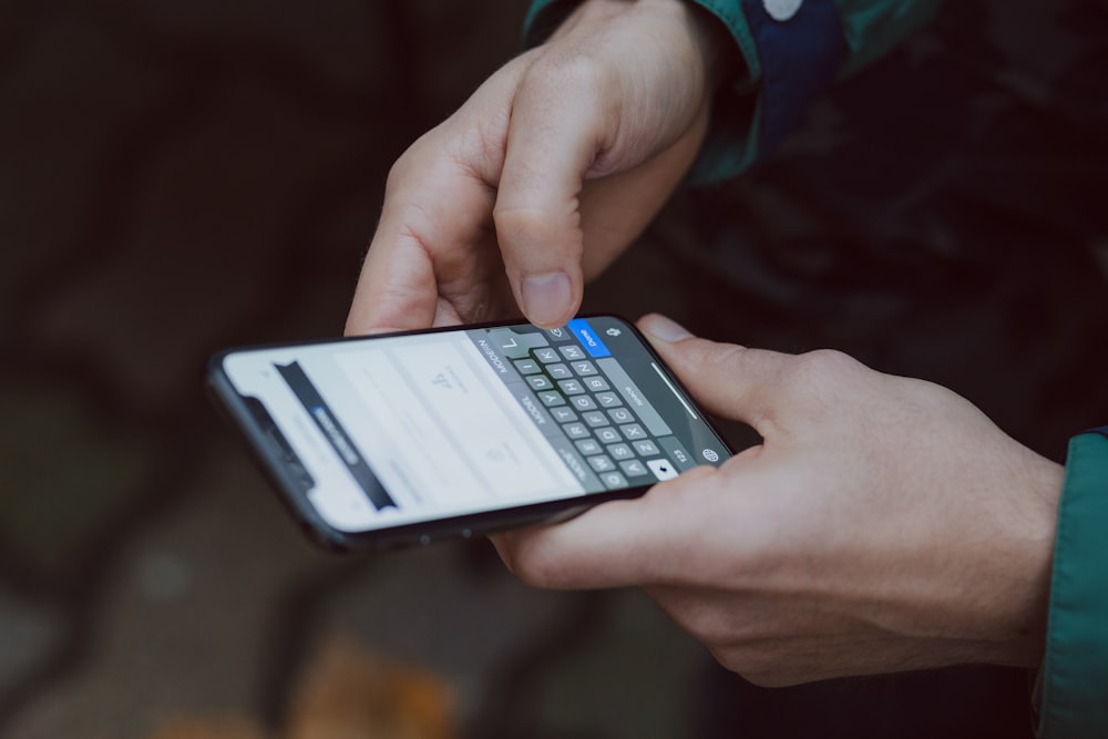 Fotografía de enfoque selectivo de una persona usando un teléfono inteligente