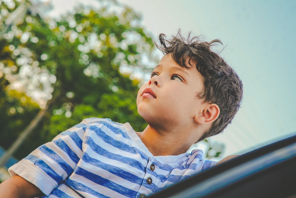 a young boy sitting in the back of a car