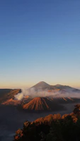 Wide shot of musæ’s rooftop at sunset with the San Salvador volcano glowing in the background.