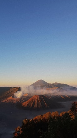 A scenic view of Masaya Volcano during sunset with tourists hiking along the path