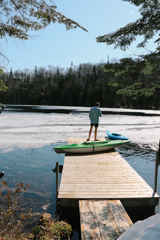 person standing on dock near kayaks in Entrelacs Canada