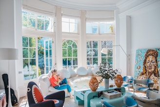 woman sitting on white couch near window