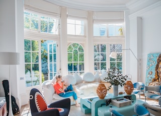 woman sitting on white couch near window