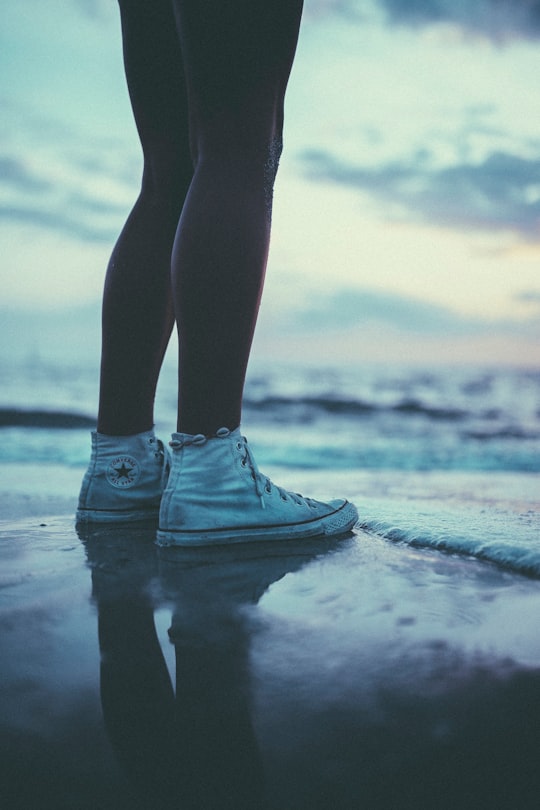 person wearing pair of white Converse All-star sneakers in Naples United States