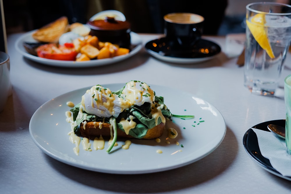 Carne cruda con panna e verdure a foglia su piatto rotondo in ceramica bianca