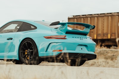 teal sedan beside trailer truck porsche google meet background