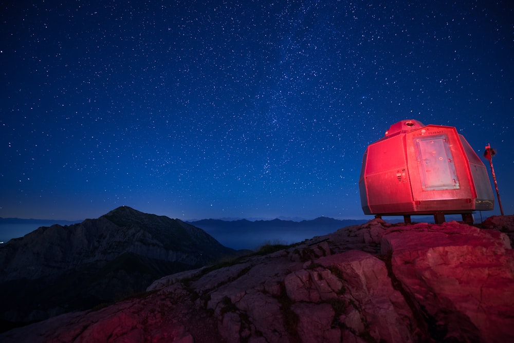 casa portatile grigia in cima alla roccia con stelle in cielo