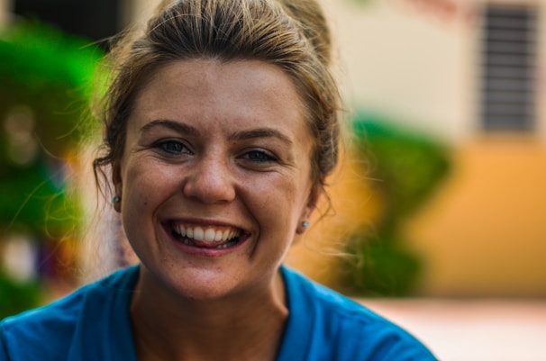 Portrait photo of a smiling female elementary school teacher with a blue background