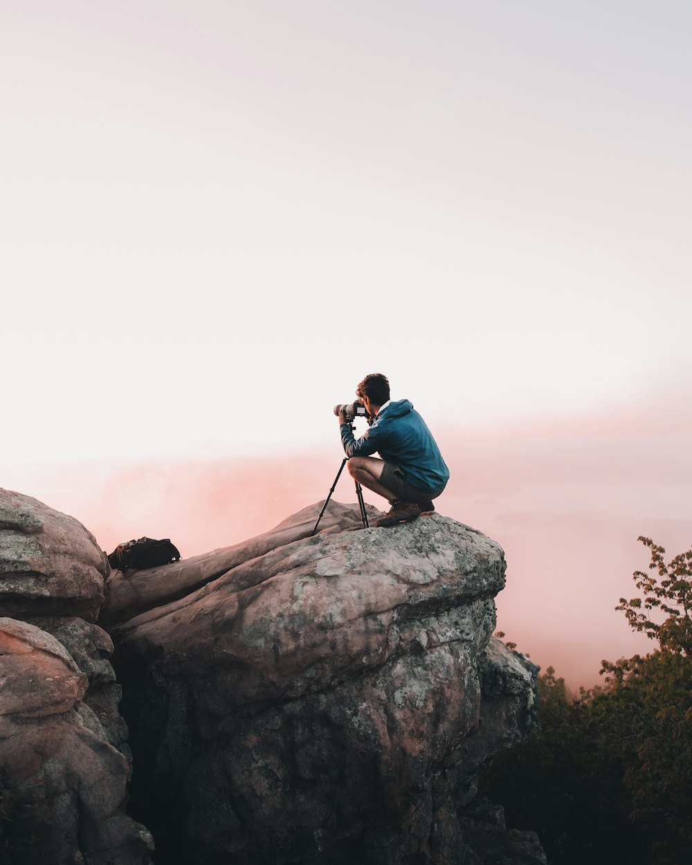 man using telescope white standing on mountain edge