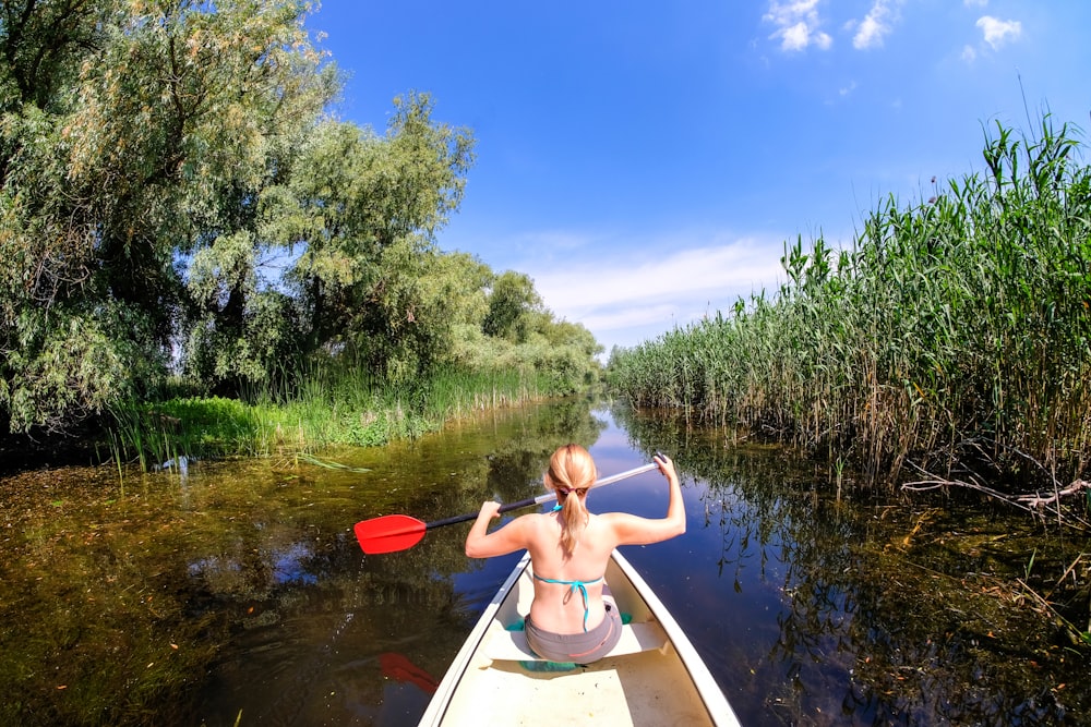 femme équitation bateau tenant une pagaie