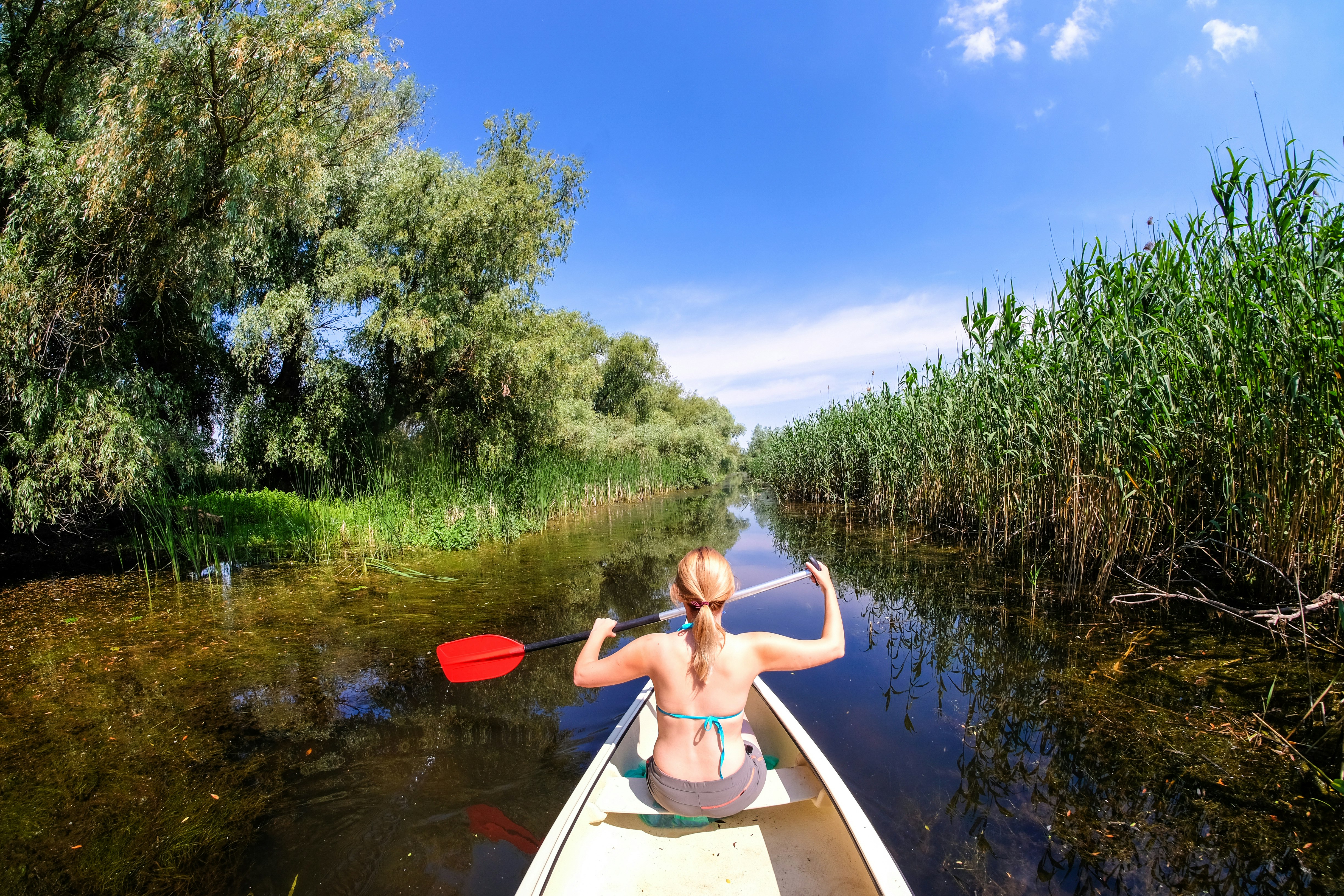 woman riding boat holding paddle