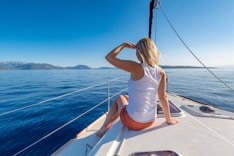 woman sitting on yacht looking mountain