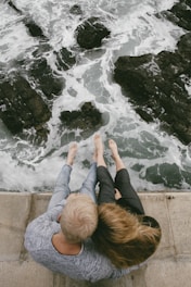 man and woman sitting on cliff near body of water needing hiv prevention