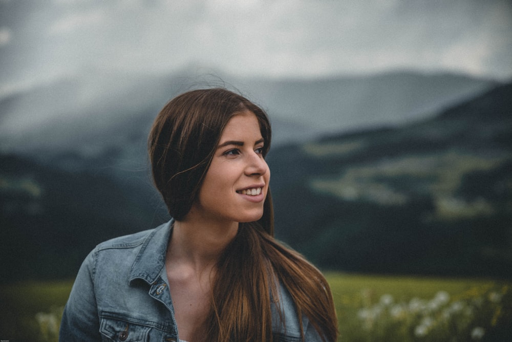 woman in denim jacket and mountain at distance