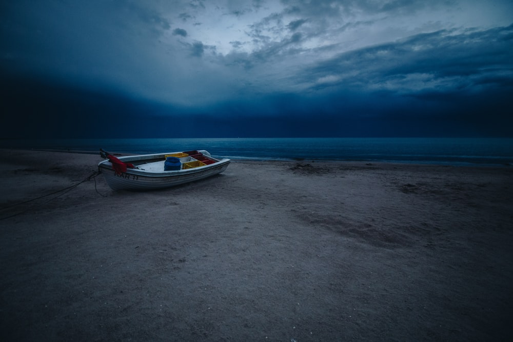 rule of thirds photography of white boat on seashore