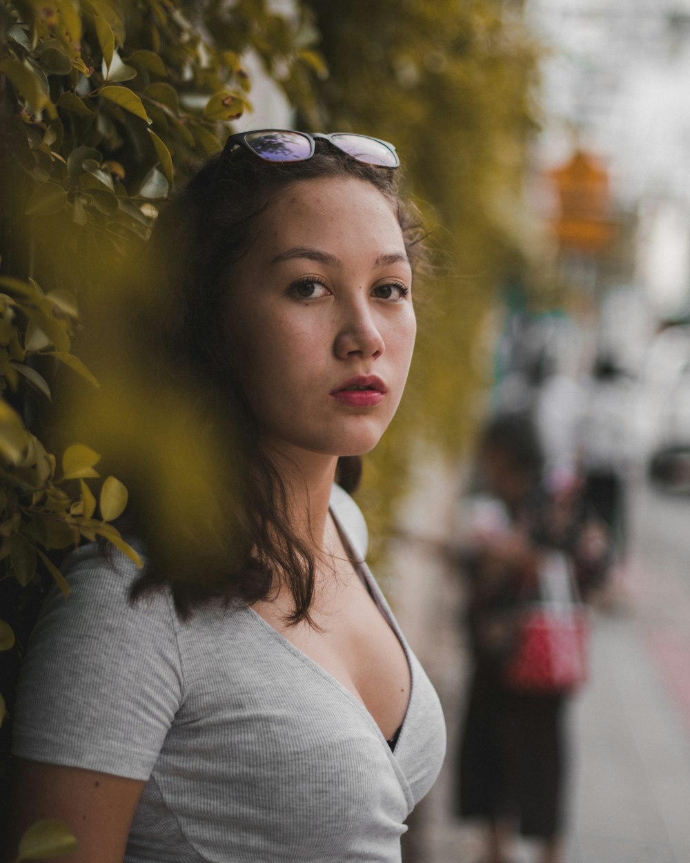 selective focus photography of woman standing near the tree