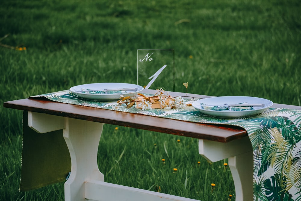 two white ceramic plates on brown wooden dining table