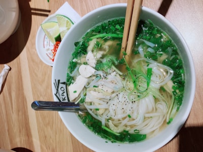 Delicious mie ayam topped with chopped green onions and slices of chicken.