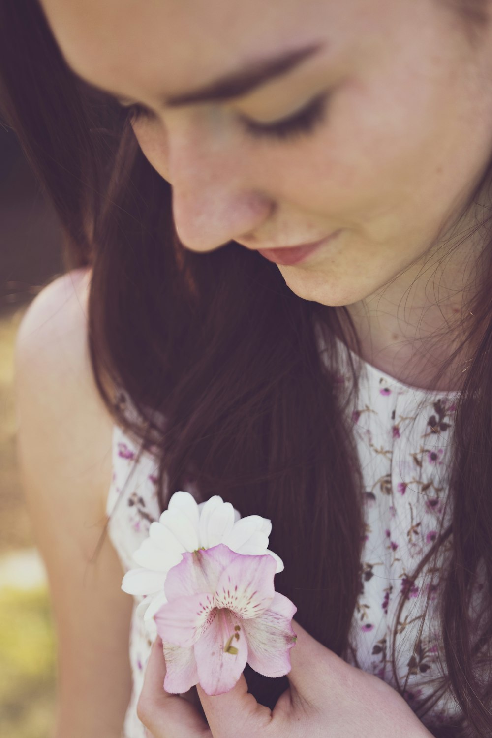 mujer sosteniendo orquídeas blancas y moradas