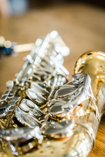 Close-up of a craftsman carefully repairing a wooden saxophone in a cozy workshop.