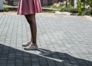 woman in pink spaghetti-strap mini dress using smartphone