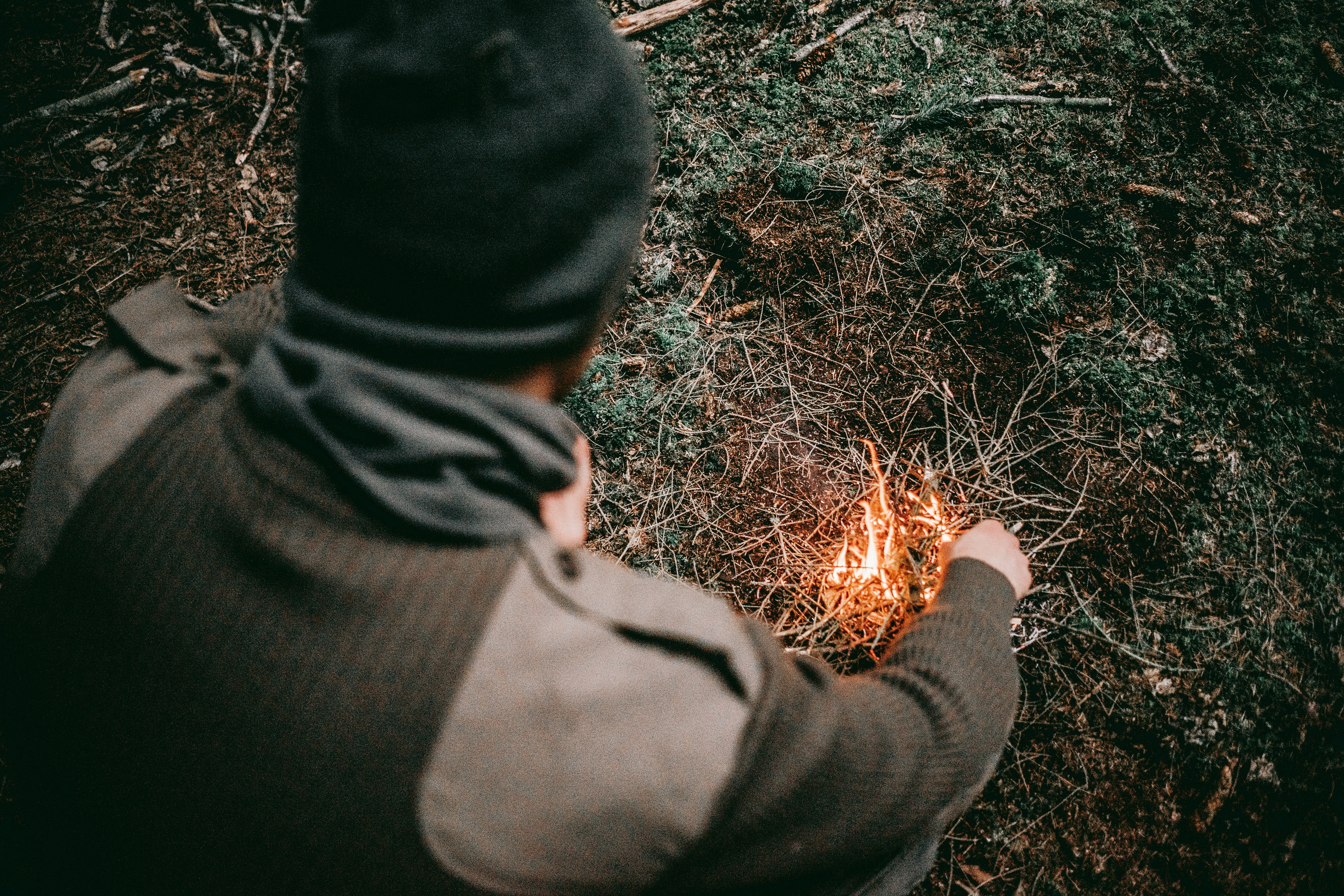 man making fire with grass