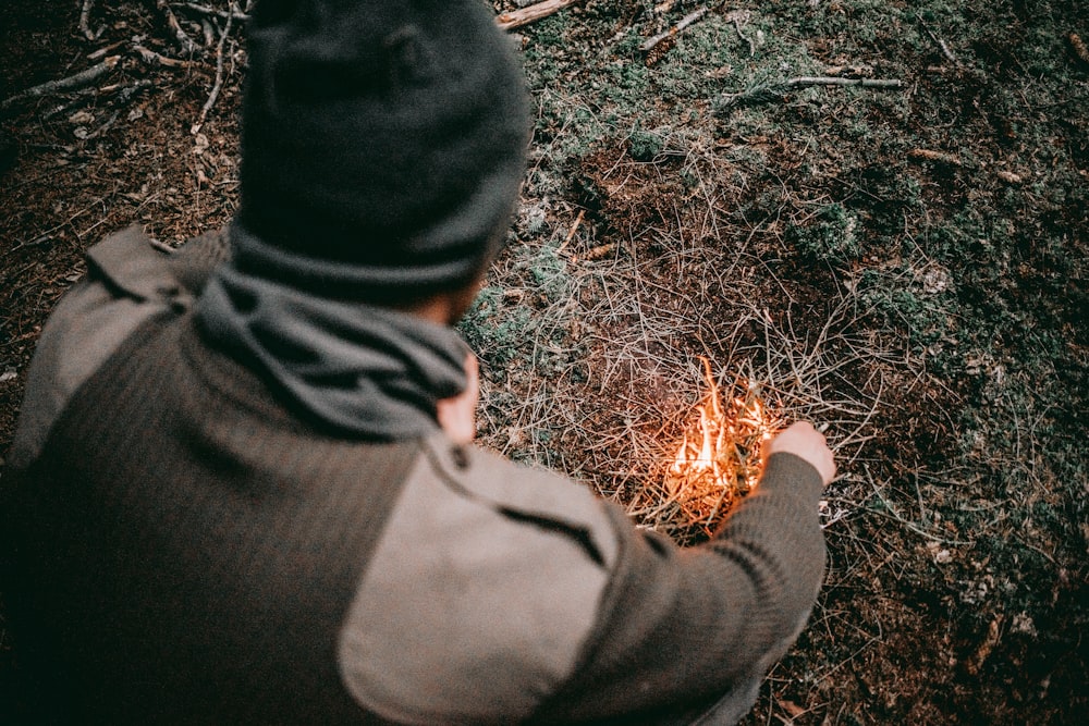 man making fire with grass