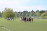 Teams competing in bubble soccer on a green outdoor field, full of energy and laughter