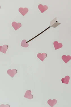 A charming illustration of Cupid aiming his arrow surrounded by glowing love hearts.