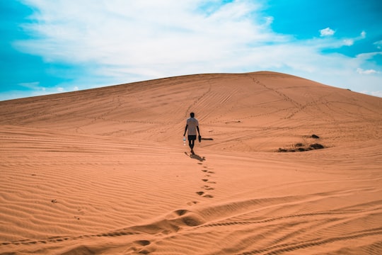 man walking on sand dunes in Mui Ne Vietnam