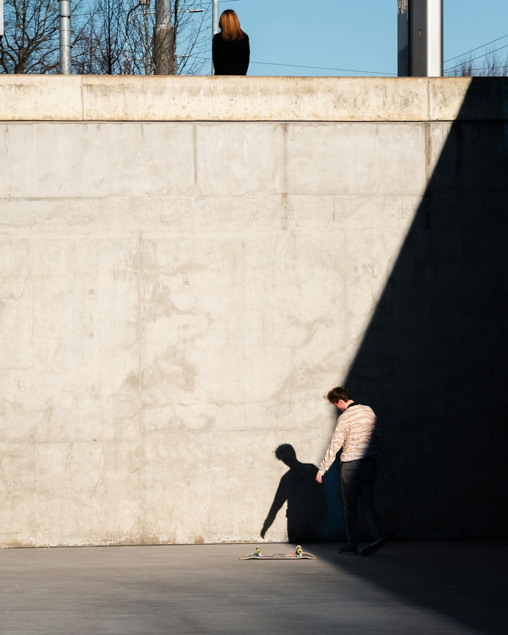 homme debout à côté de la planche à roulettes