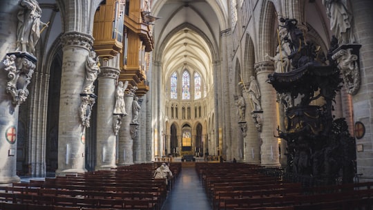 people sitting in pew inside cathedral in St Michael and St Gudula Cathedral, Brussels Belgium