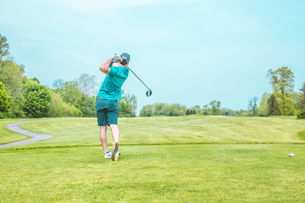 man playing gold under blue sky during daytime